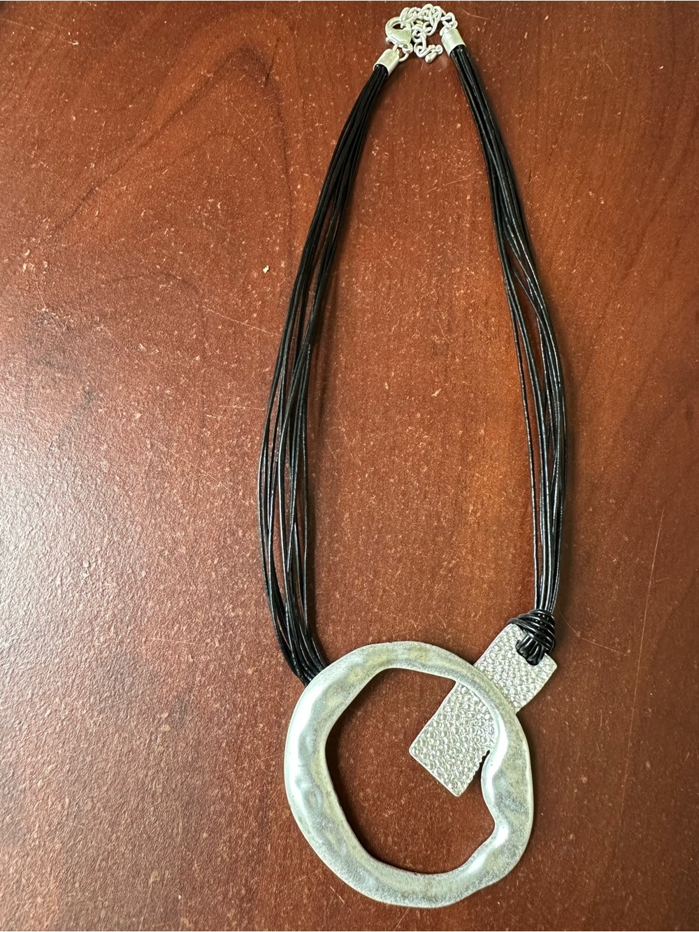 Black Multi-Strand Necklace with Silver Textured Ring Pendant